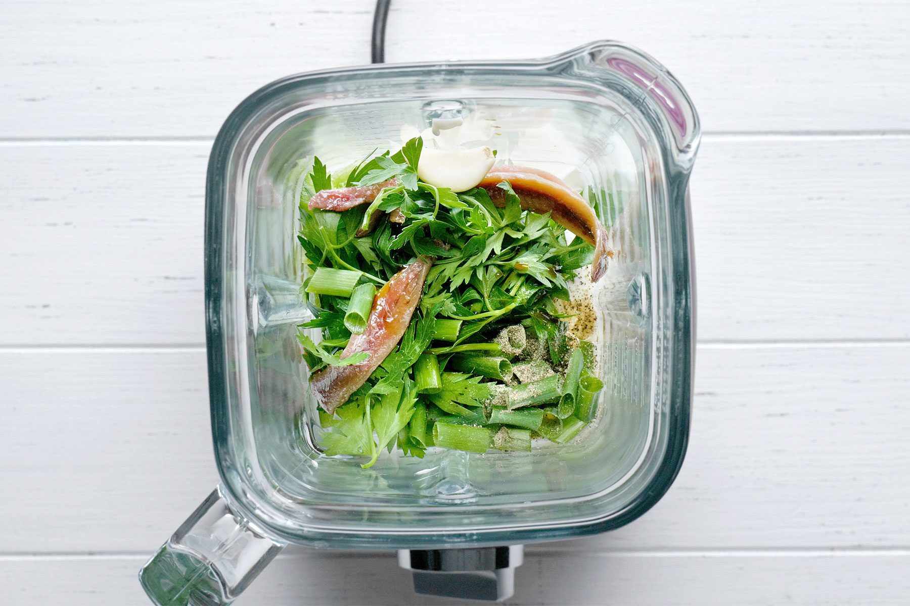 Overhead shot of placed all ingredients in a blender; cover and process until smooth; white wooden background;