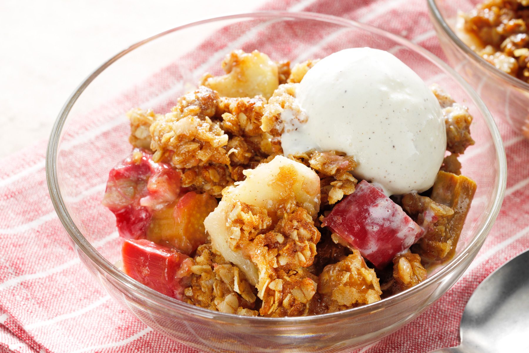 A bowl of rhubarb crisp topped with vanilla ice cream