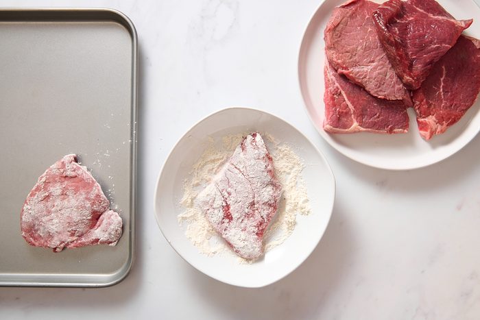 Dredging steak in flour to make slow cooker Swiss steak