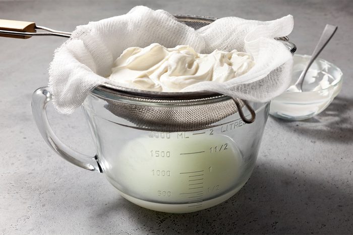 line a fine mesh strainer with two layers of cheesecloth; Place yogurt in strainer over a bowl