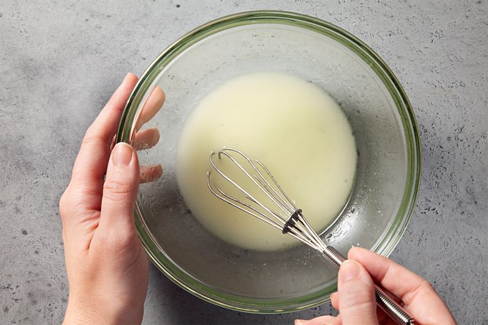 a person whisking oil and vinegar until blended
