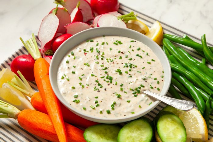 Vegan Ranch Dressing in large bowl garnished with additional chives and served with fresh veggies
