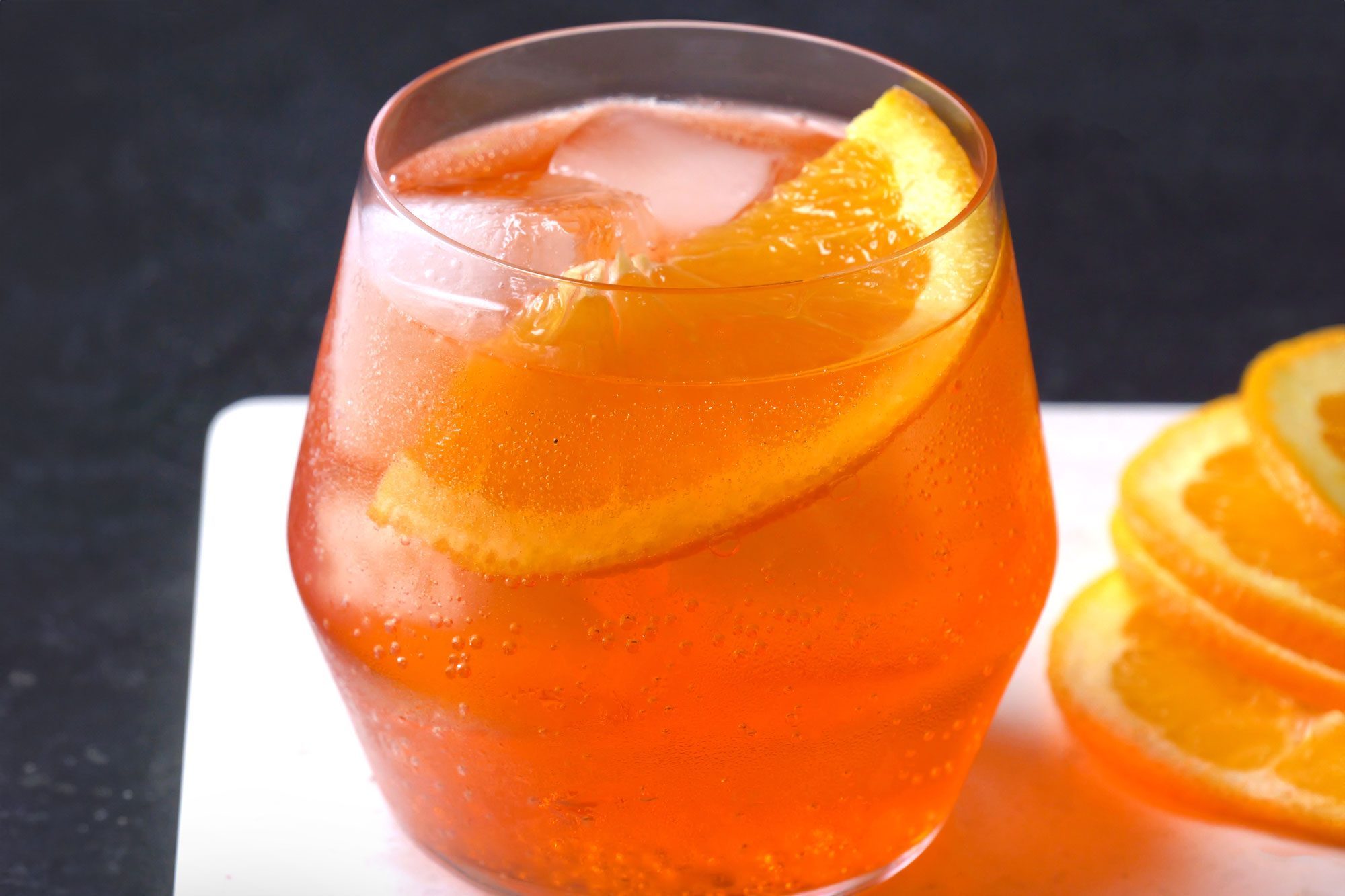 close shot of aperol spritz garnished with orange slice