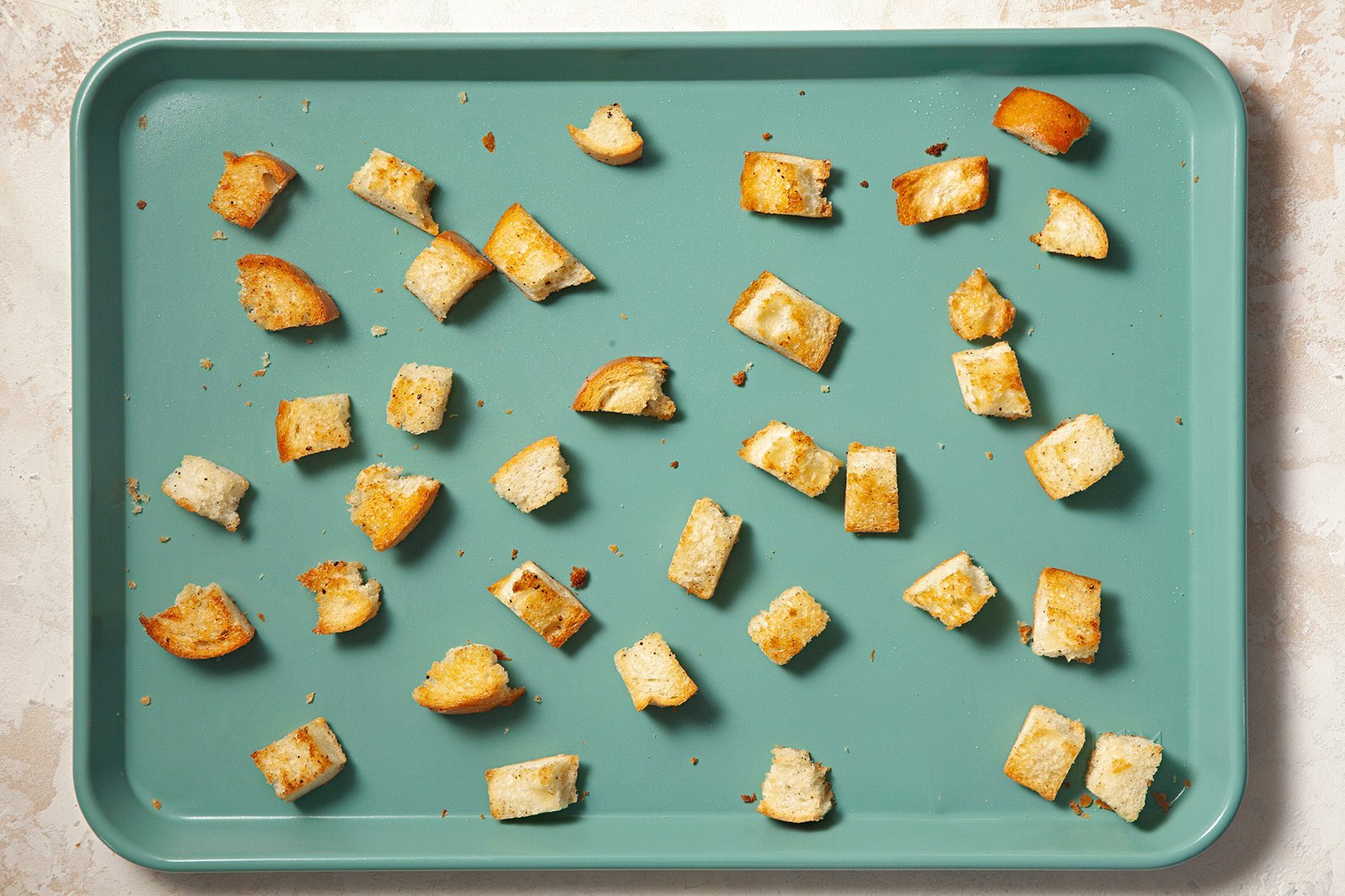 Overheda shot of baking pan; bake until golden brown; cream marble background