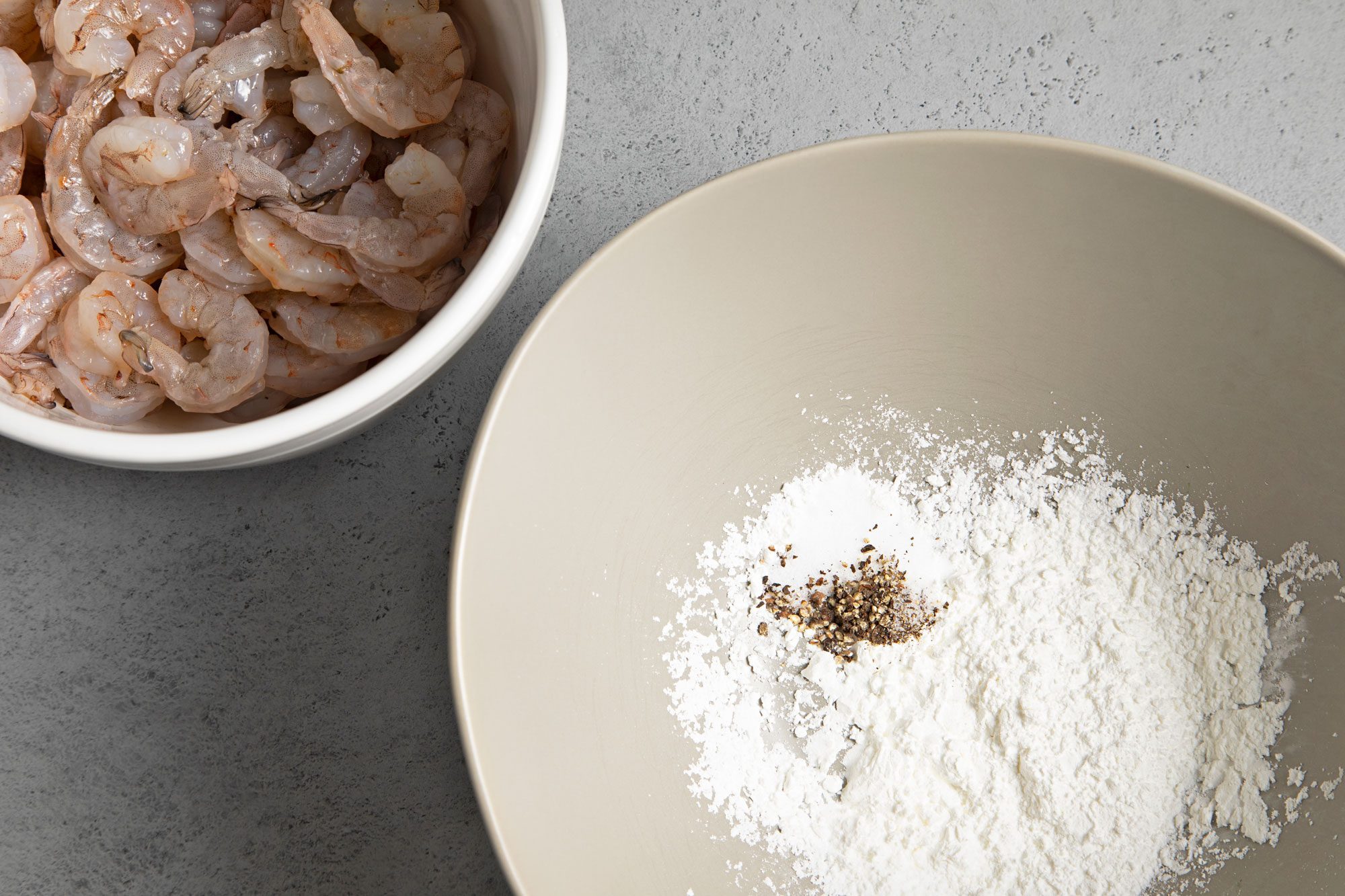 overhead shot of shrimp and cornstarch in bowls