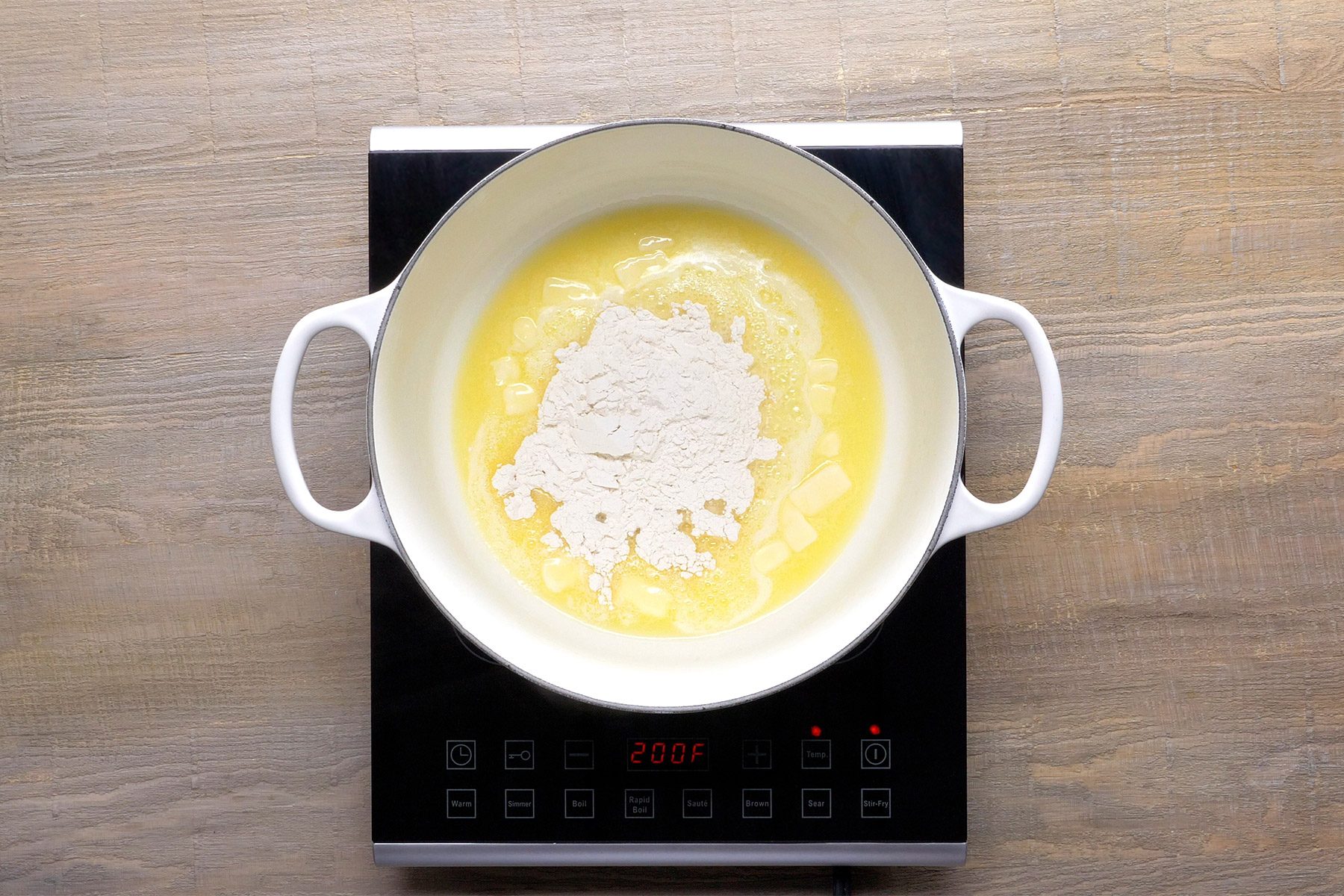 overhead shot; wooden background; In a large saucepan, melting butter over medium heat with flour;