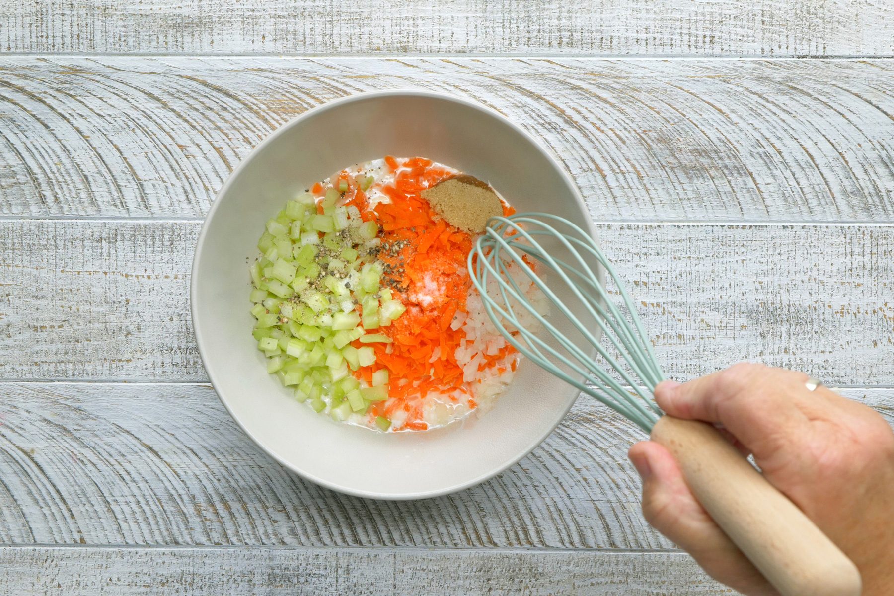 In a small bowl, whisk the vinegar with mayonnaise, milk, carrot, celery, onion, brown sugar, salt and pepper.