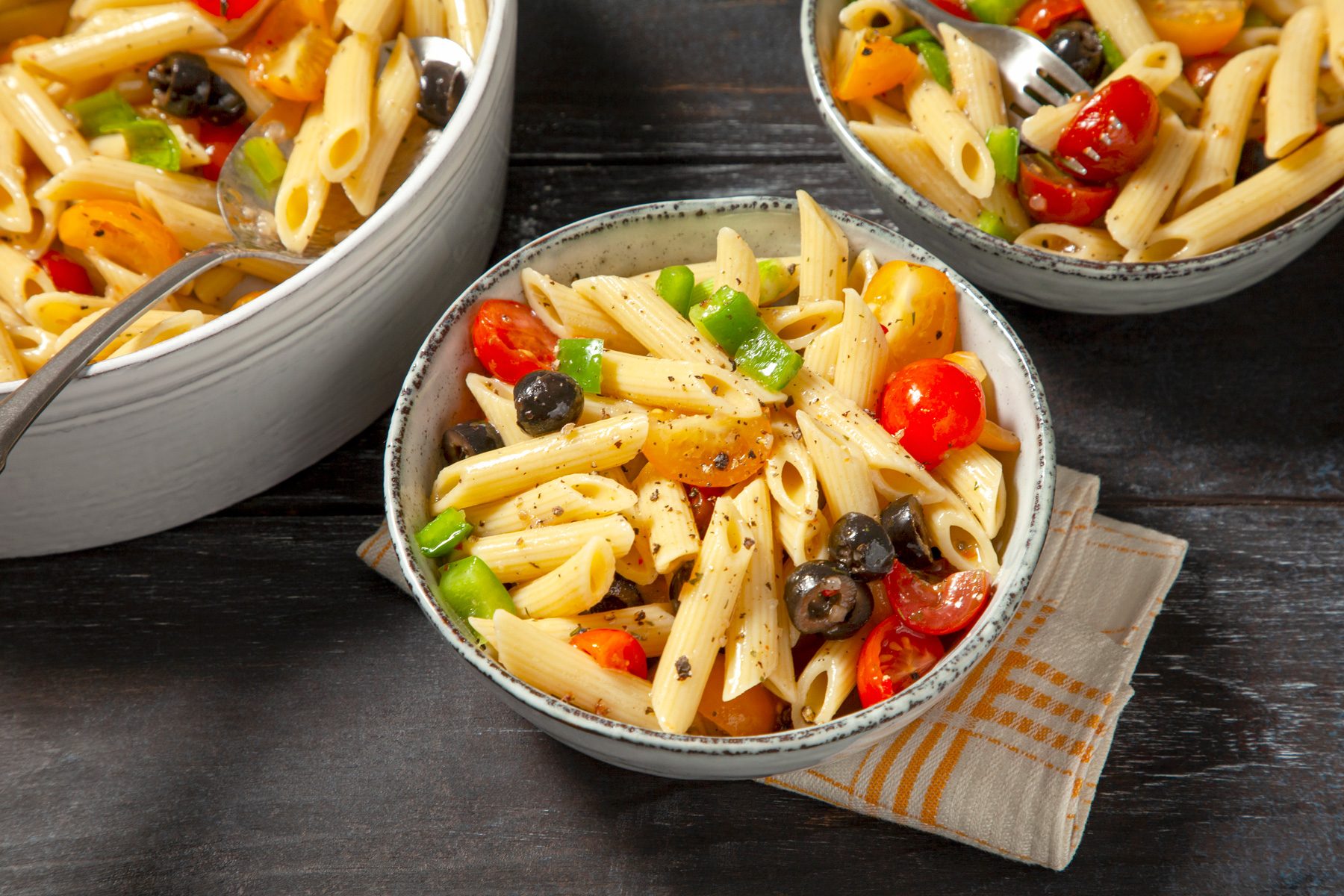 Delicious Penne Pasta Salad served in three bowls with napkin 