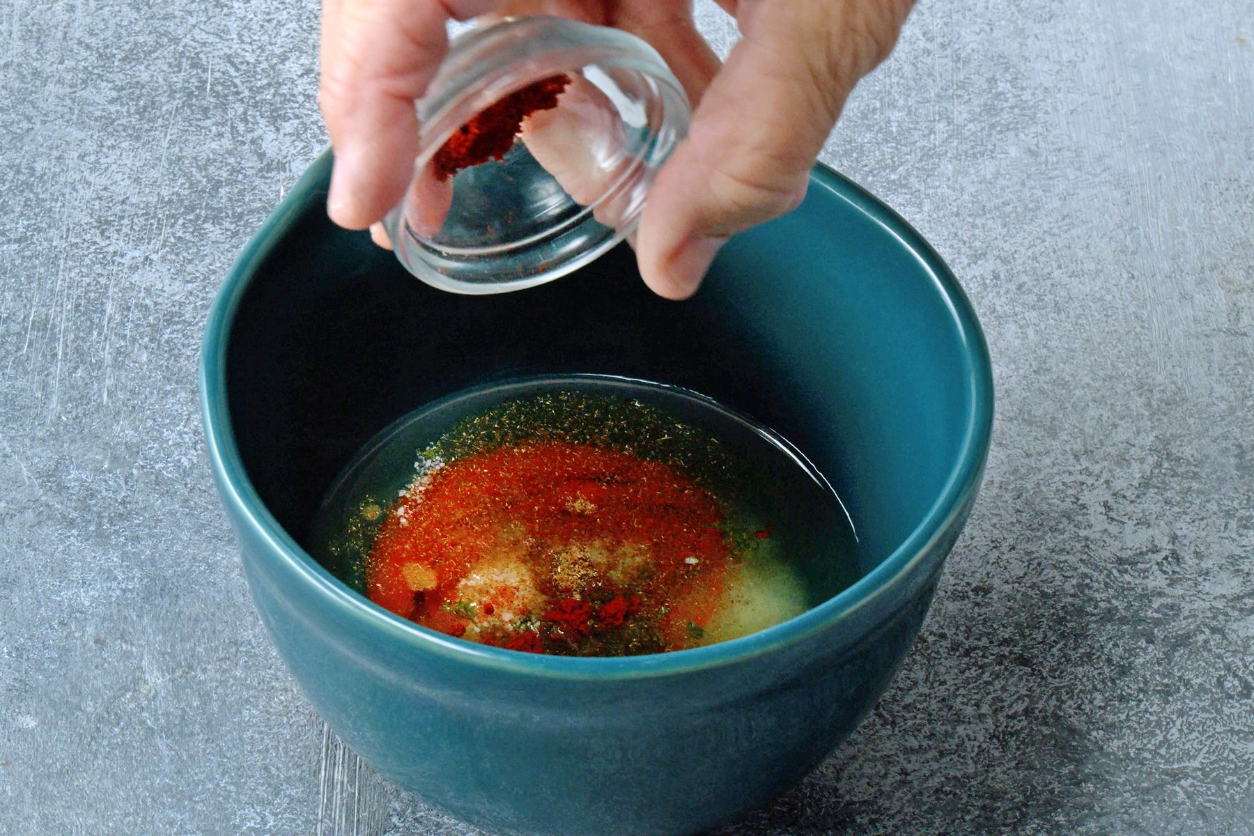 In a small bowl, whisk together the canola oil, Sriracha, lime juice, lime zest, salt, cumin and paprika until they're blended.