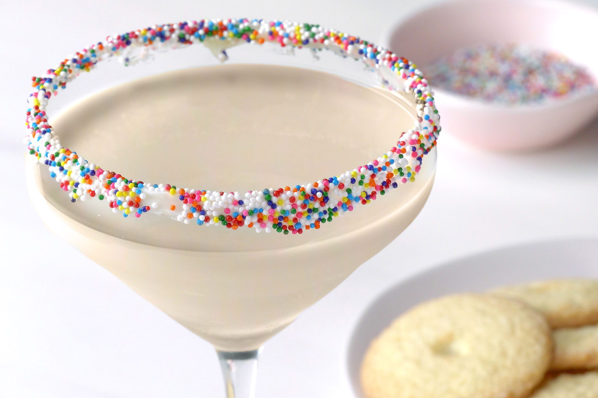 Sugar Cookie Martini served in a martini glass with Christmas sprinkles frosting