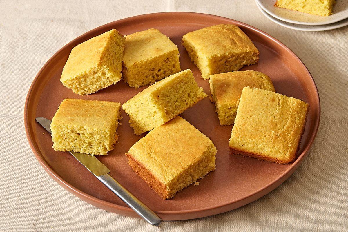 Angled shot of squares of sweet cornbread on a plate