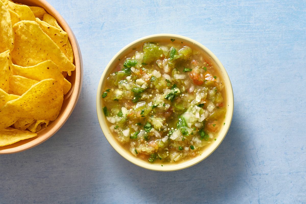 Overhead shot of tomatillo salsa served with tortilla chips