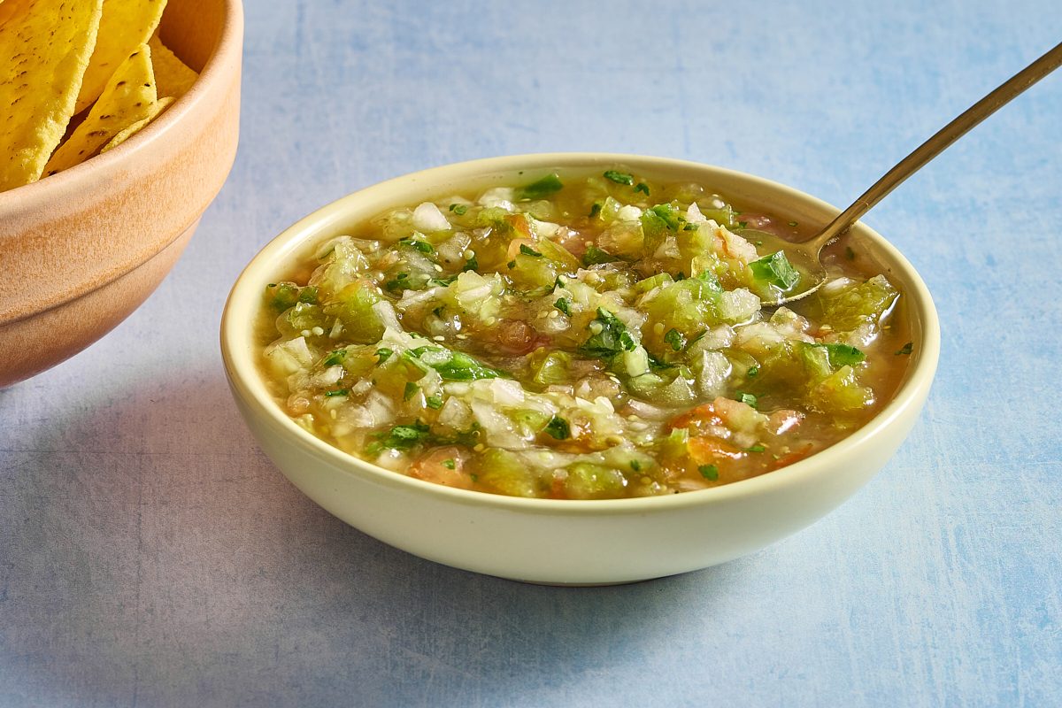 Closeup of tomatillo salsa in a bowl with a spoon