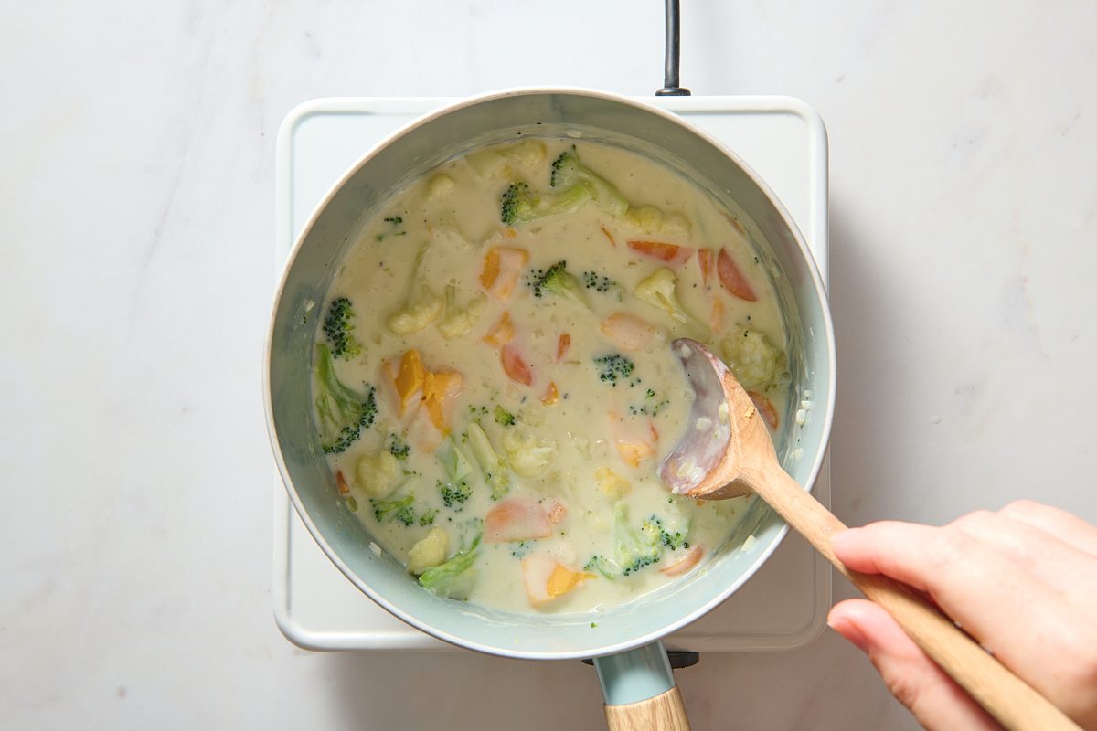 Cheese being stirred into soup 