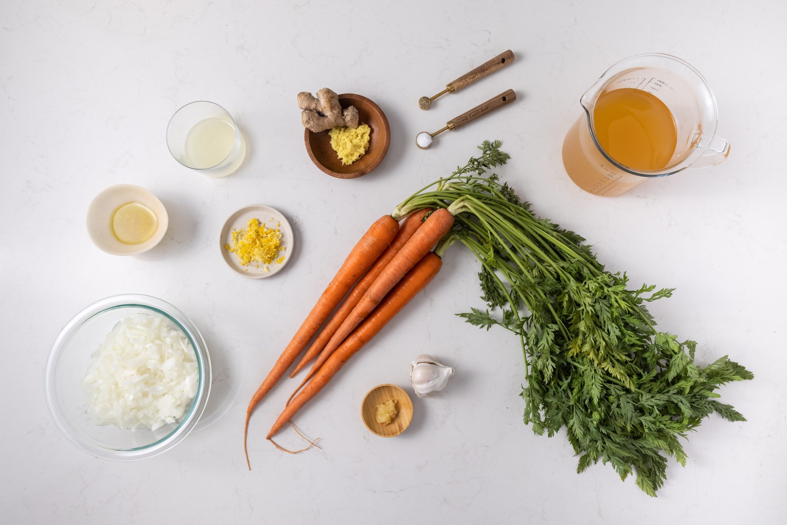 Ingredients for ginger carrot soup on kitchen counter.
