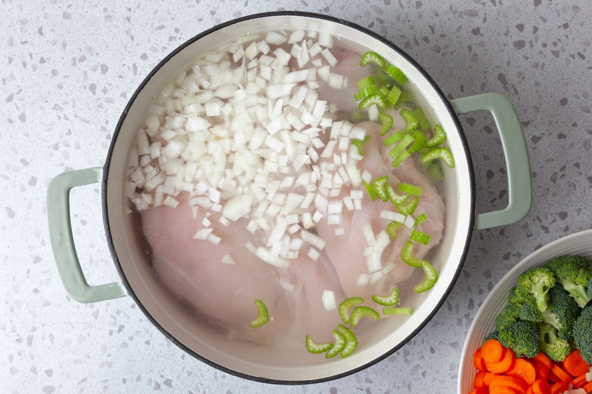 Step 1 of Taste of Home Chicken Vegetable Soup is boiling chicken, celery and onionin water until chicken is tender