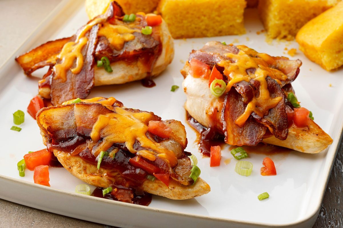 Close up of Monterey Chicken on a tray drizzled with sauce and topped with cheese