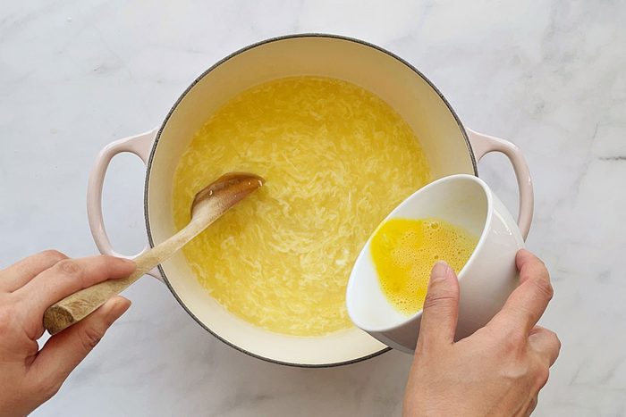 Step 2 in how to make Taste of Home's Egg Drop Soup recipe; whisking in egg