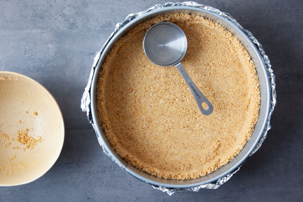 Step 2 of Taste of Home Eggnog Cheesecake is to make the graham cracker crust and press it into the pan before baking