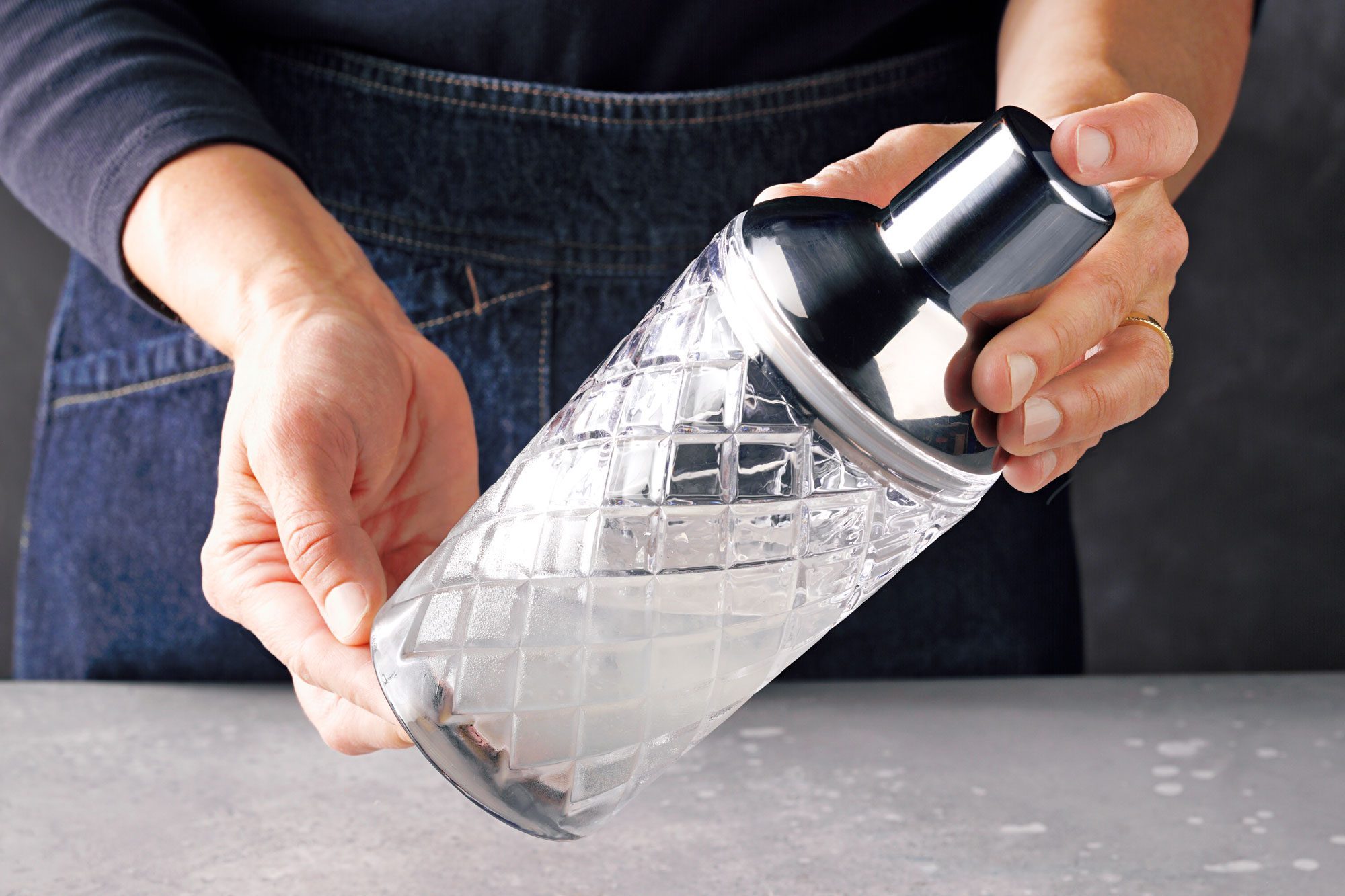 Table view shot of cover the shaker; and shake until condensation forms on outside of shaker; marble background;