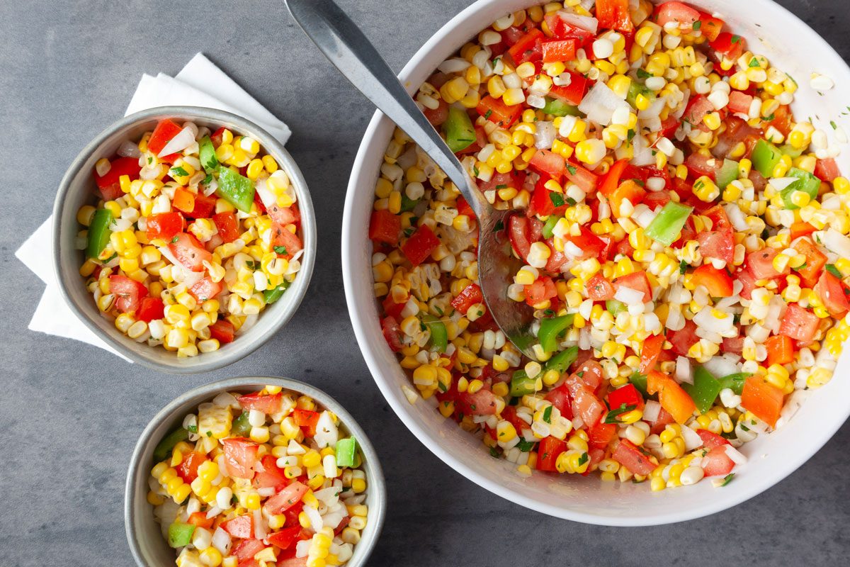 Full yield of Taste of Home Fresh Corn Salad in a large serving bowl, plus two single servings