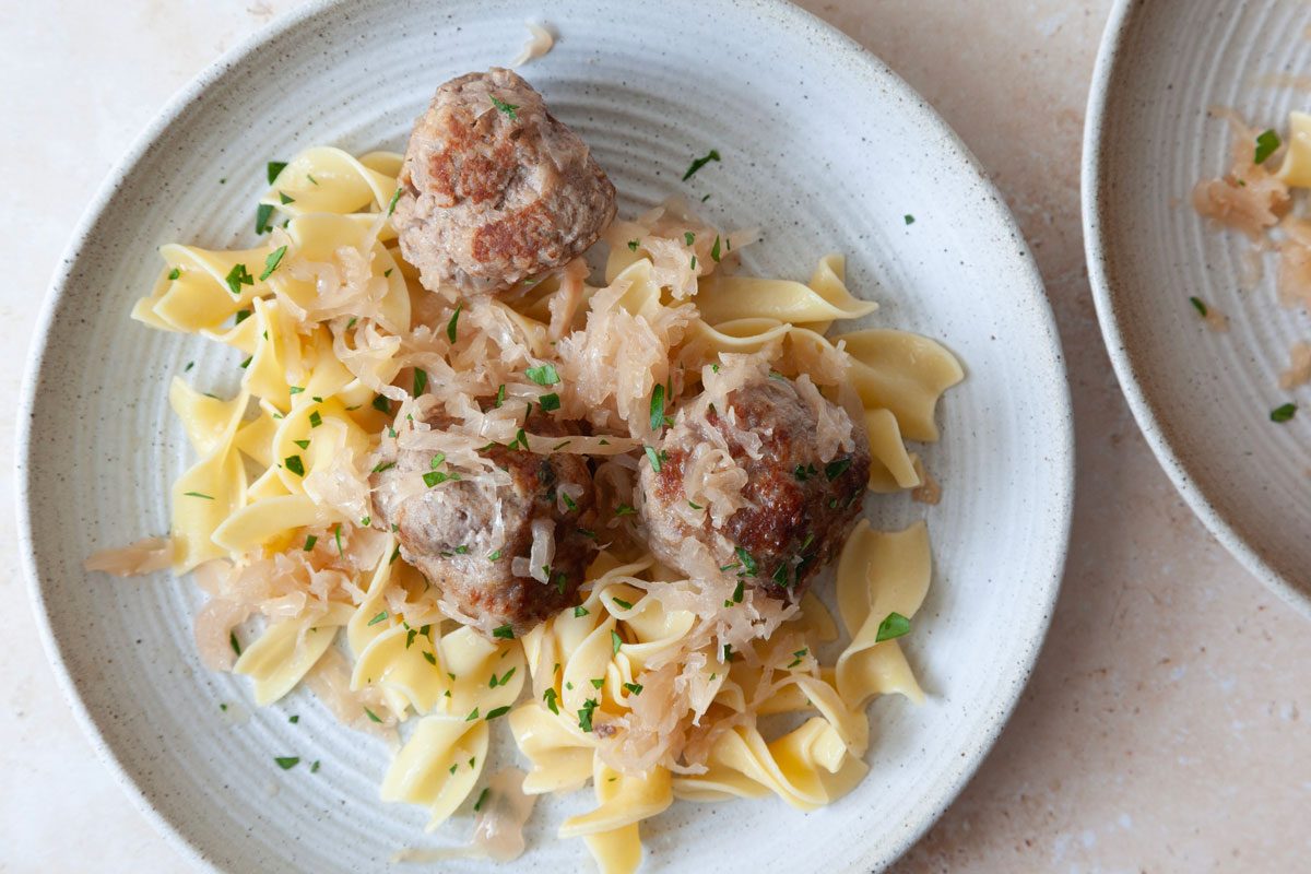 Single servings of Taste of Home German Meatballs over egg noodles garnished with parsley