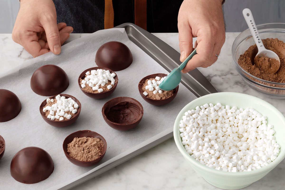 filling hot chocolate bomb shells with mouse and mini marshmallows