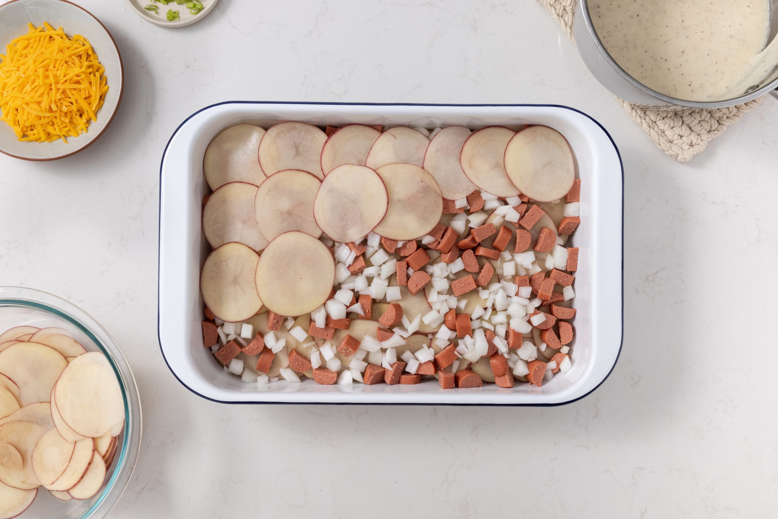 hot dog casserole being prepared and layered to be baked.