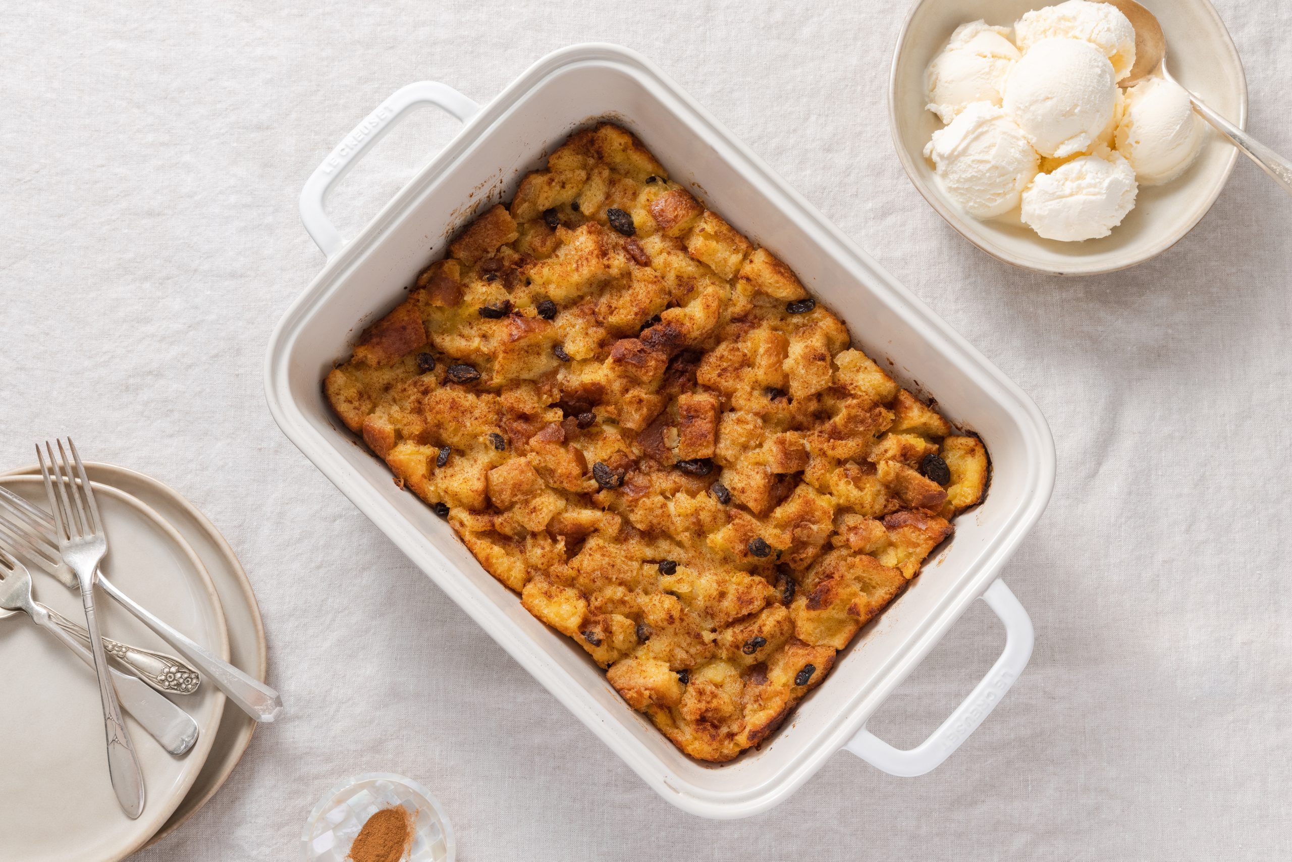 Pineapple bread pudding baked and served in baking dish with ice cream on the side.