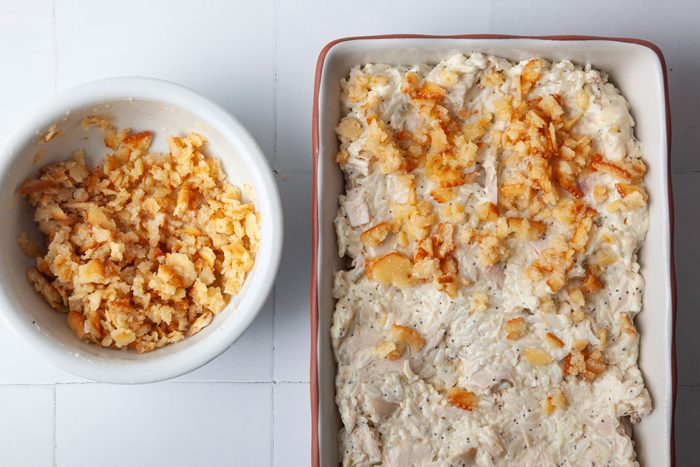 Step 2 of Taste of Home Poppy Seed Chicken is to add the chicken mixture to an 11x7 baking dish and top with buttered crackers mixed with melted butter