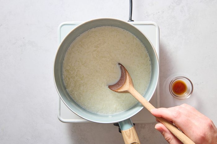 Stirring rice pudding in a large saucepan