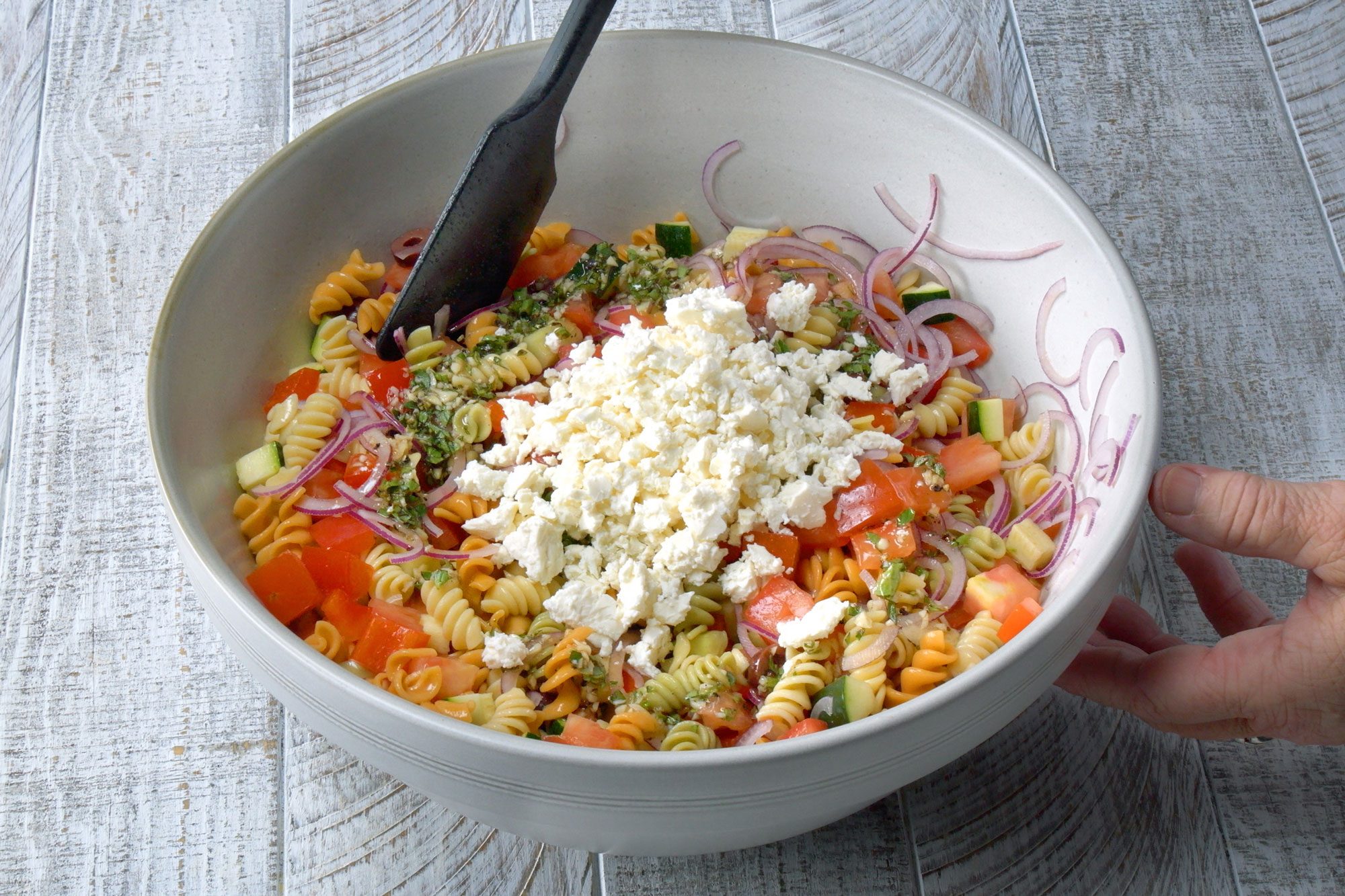 add grated cheese in the salad mix; wooden background;