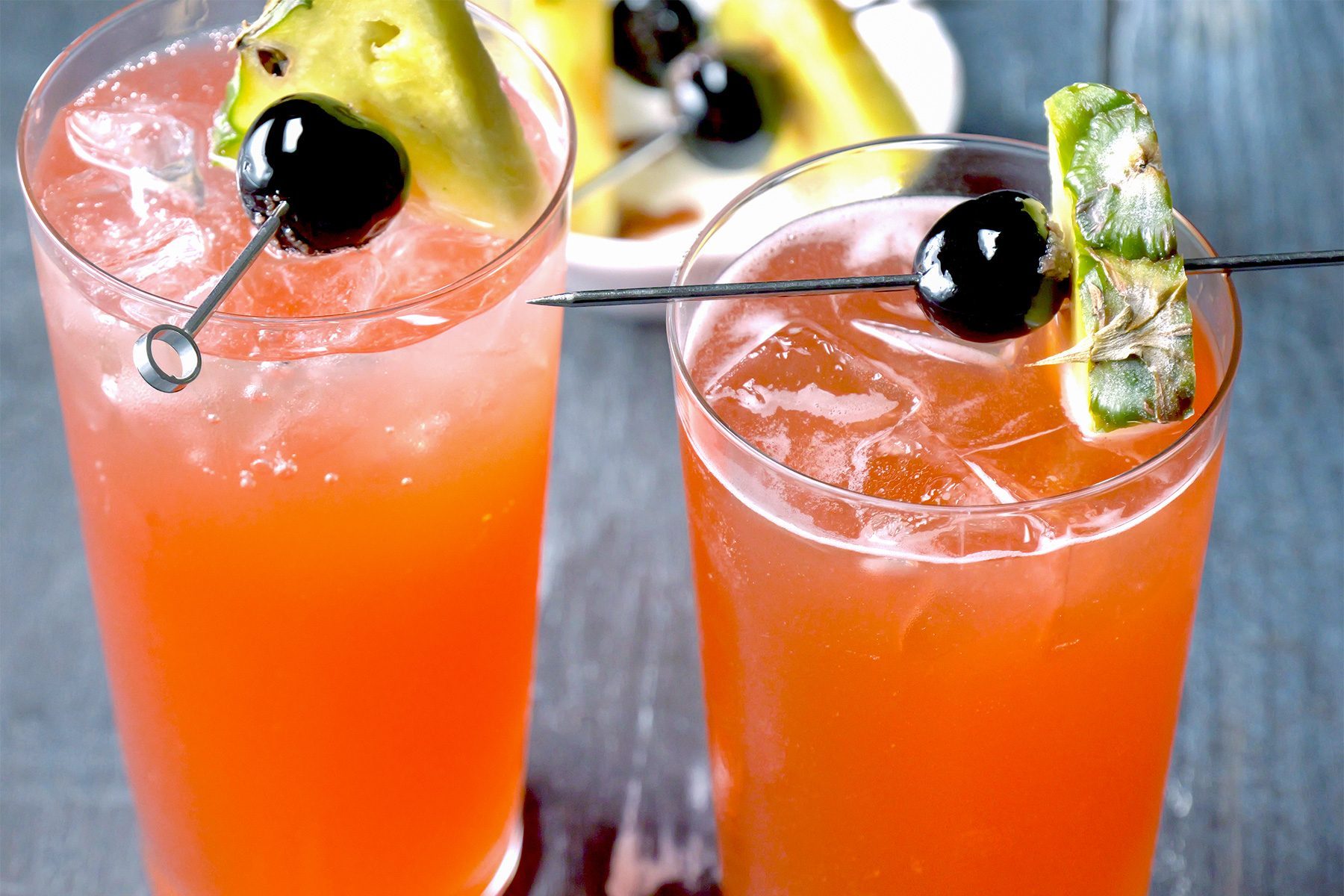 3/4th shot; wooden background; Singapore Sling served into chilled sling glass; top with club soda; Garnish with cherries;