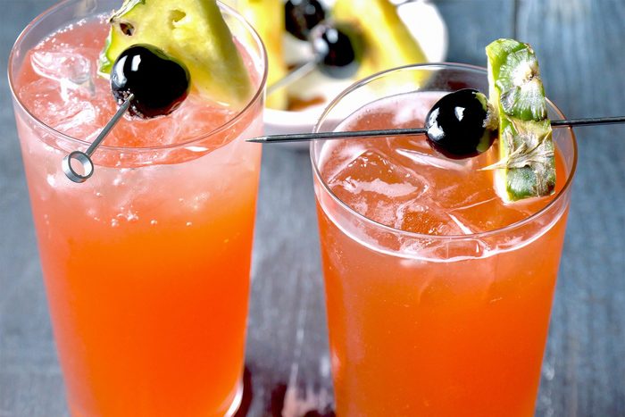 3/4th shot; wooden background; Singapore Sling served into chilled sling glass; top with club soda; Garnish with cherries;