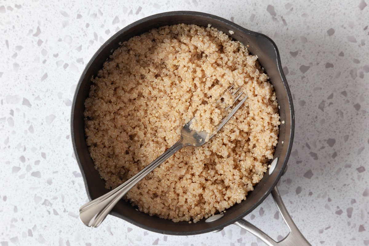 quinoa in a saucepan being fluffed with a fork