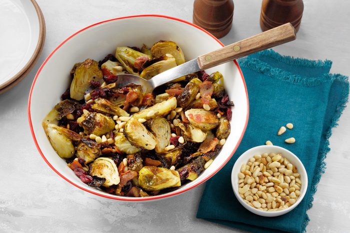 Roasted Balsamic Brussels Sprouts With Pancetta in a serving bowl with a spoon