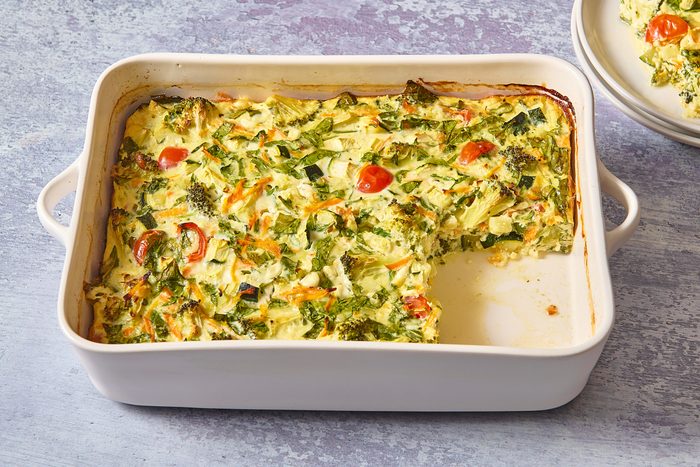 Veggie egg casserole in a baking dish with a slice cut out