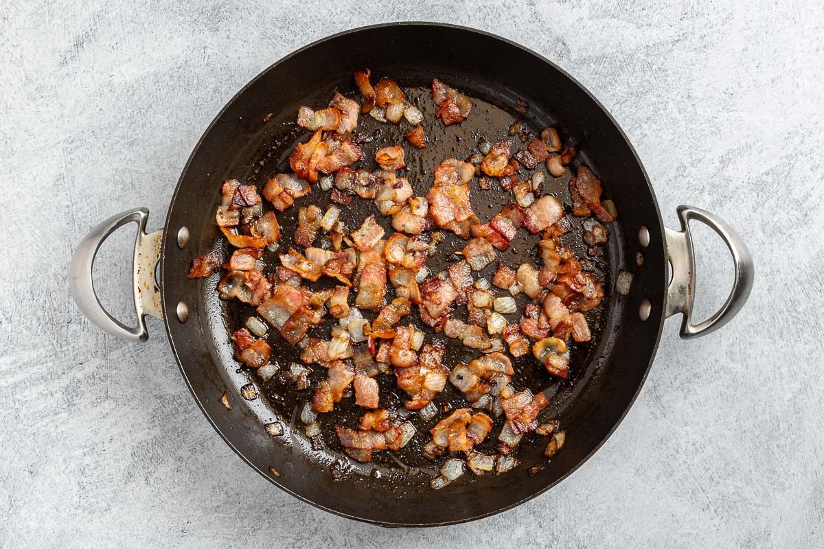 Taste of Home Bacon Pasta recipe photo of the cooked bacon and onion in a large skillet.