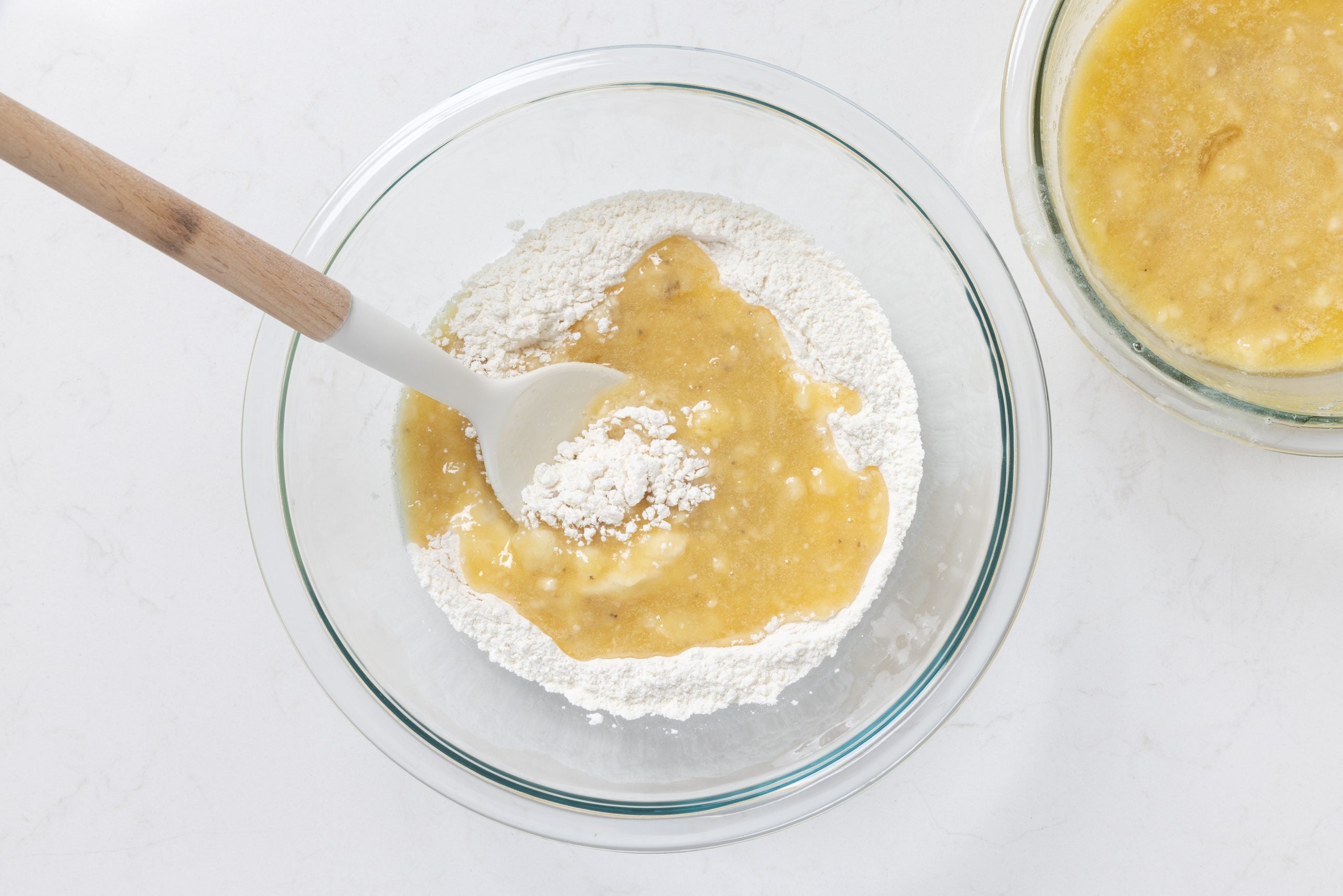 Wet ingredients and dry ingredients being combined in mixing bowl.