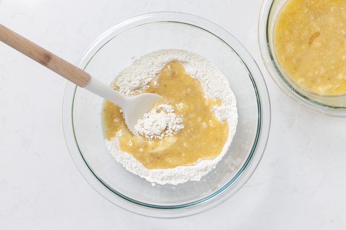 Wet ingredients and dry ingredients being combined in mixing bowl.