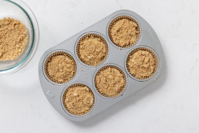 Muffins with crumb topping on them ready to be baked.