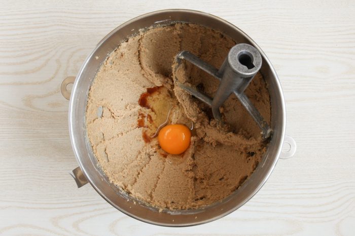 Adding egg to cookie dough batter