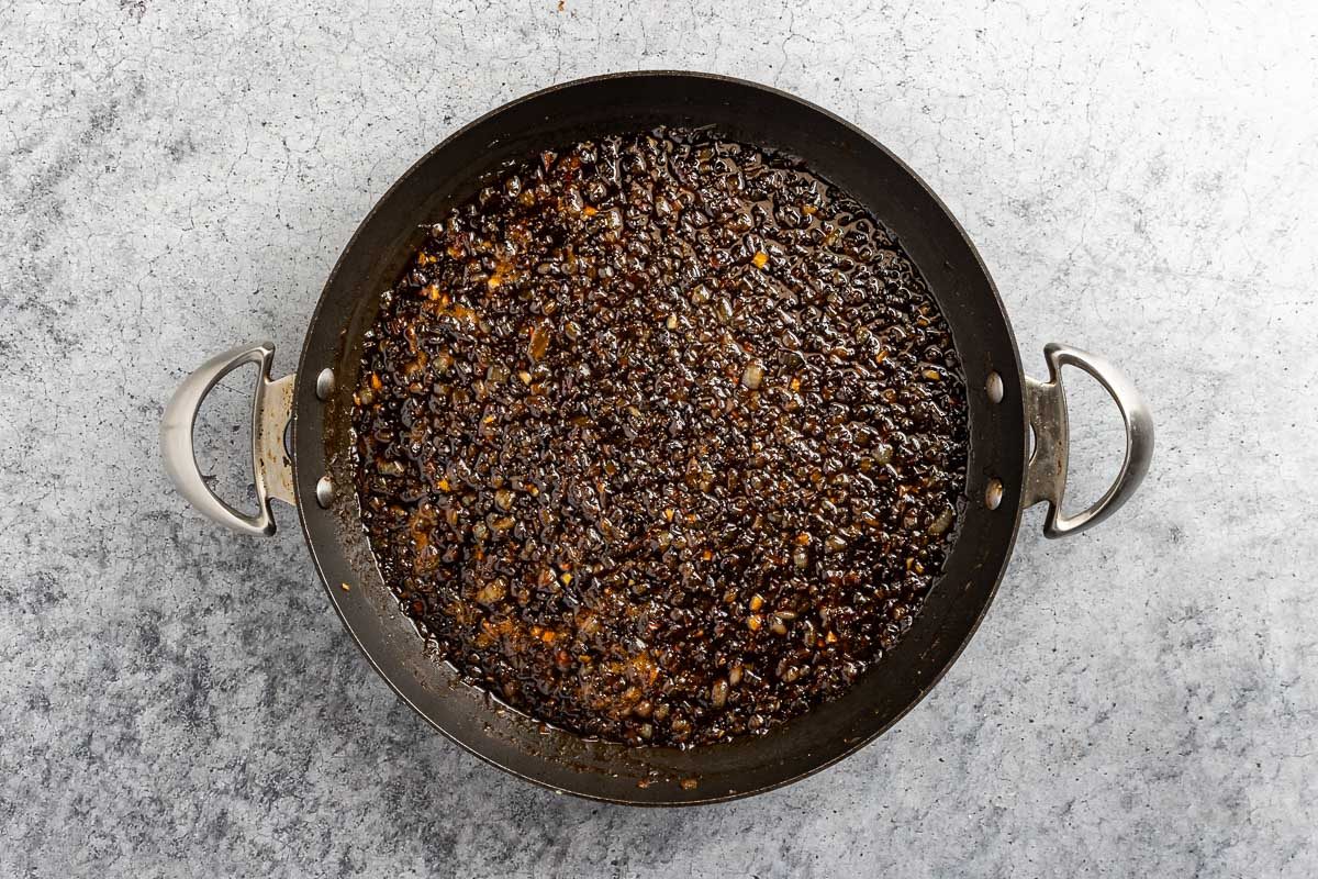 Taste of Home Bourbon Bacon Jam recipe photo of bourbon, maple syrup, vinegar, and brown sugar added to the mixture.