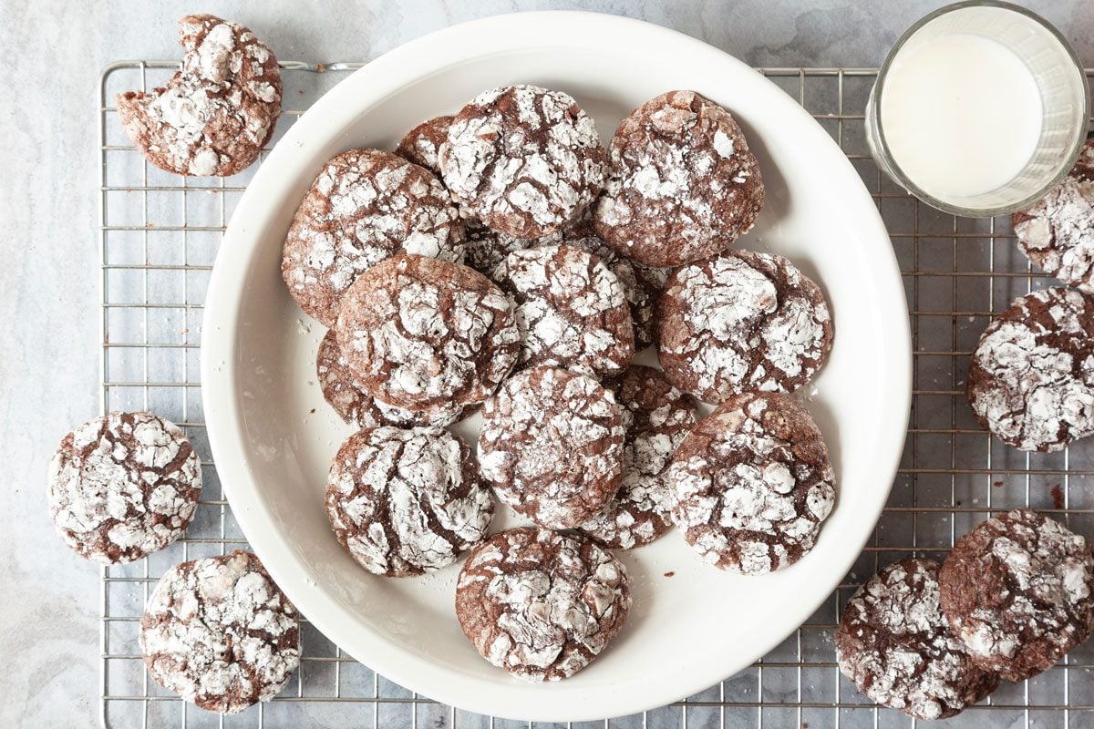 Full yield of Taste of Home Brownie Mix Cookies on a cooling rack and a white plate, glass of milk