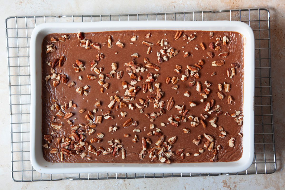 Step 4 of Taste of Home Buttermilk Chocolate Cake is to make the frosting and frost the cake, sprinkle with pecans and cool on a wire rack
