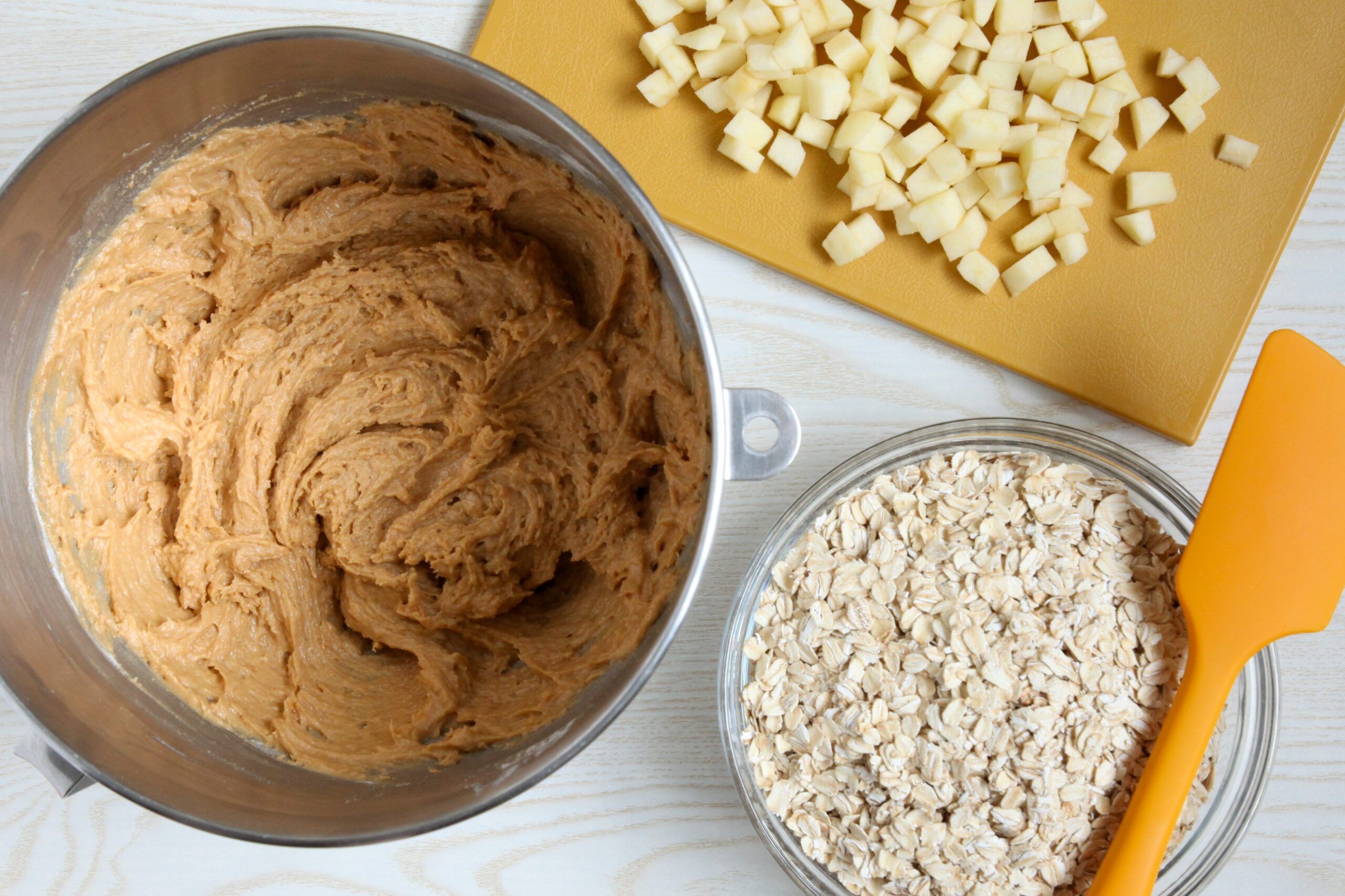 Adding apples and oats to cookie dough