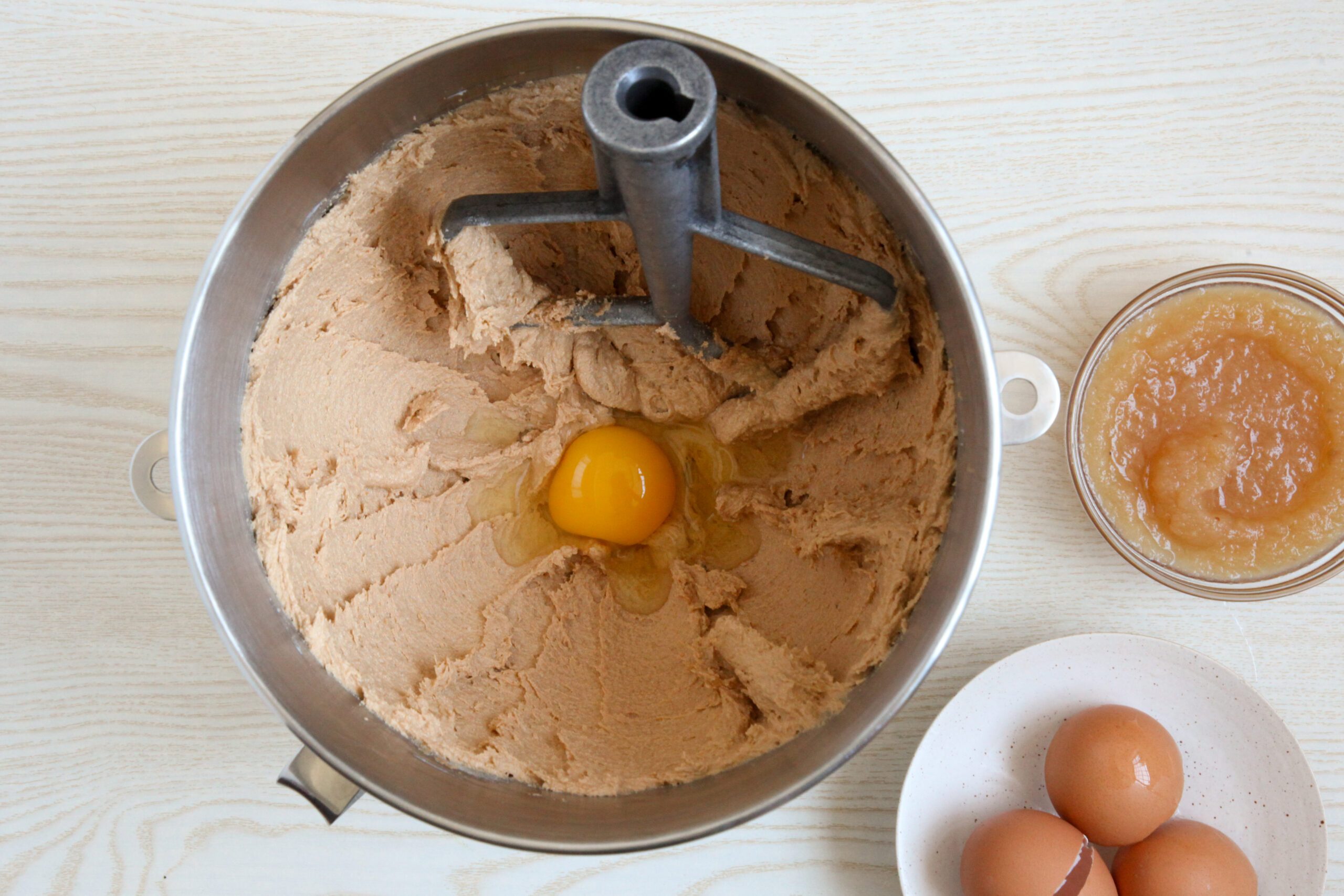 Adding eggs and applesauce to cookie dough