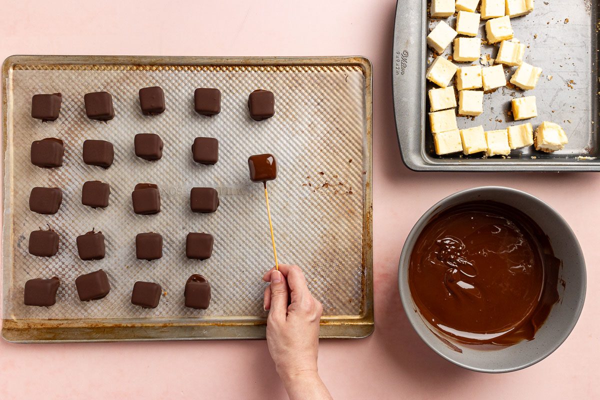 Taste of Home Cheesecake Bites recipe photo of the squares dipped in chocolate.