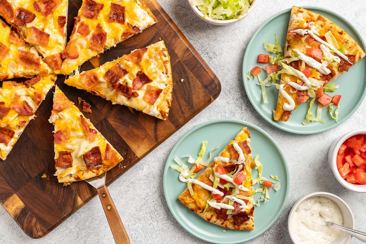 Taste of Home Chicken Bacon Ranch Pizza recipe photo of the pizza sliced and served on plates.
