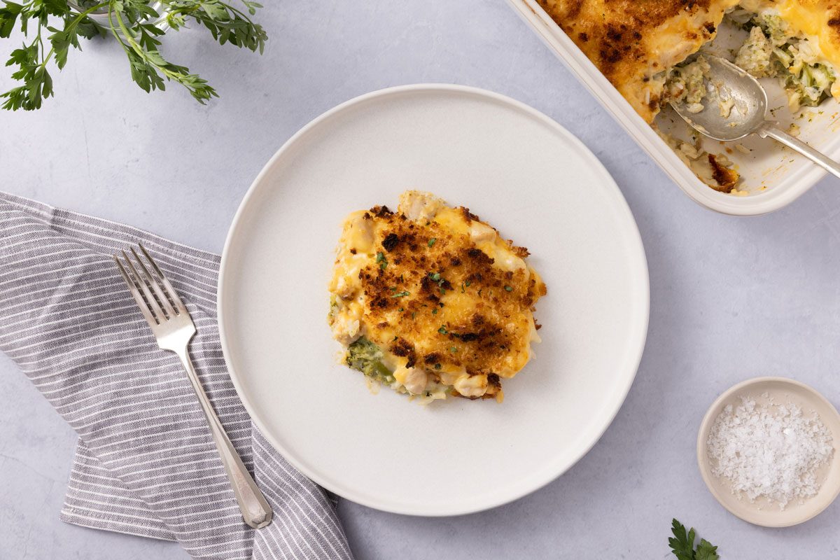 Casserole Served On Plate With Baking Dish Close By.
